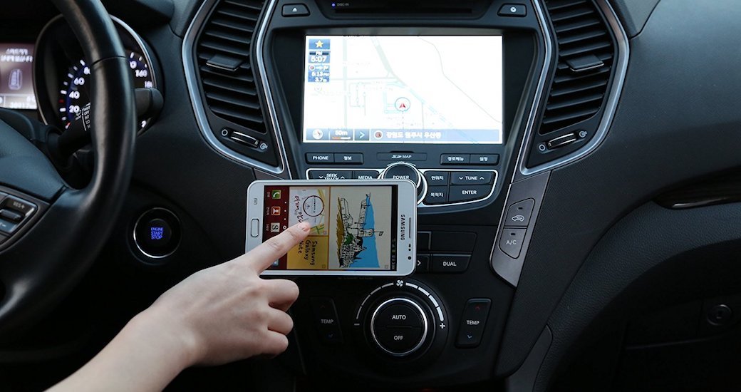 A hand touching a phone on a car mount