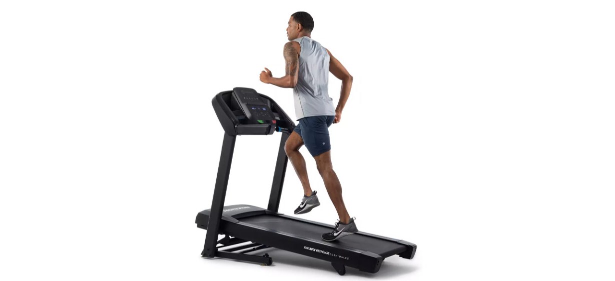 Man using Horizon Fitness T101 Go Series Treadmill on white background Man using Horizon Fitness T101 Go Series Treadmill on white background