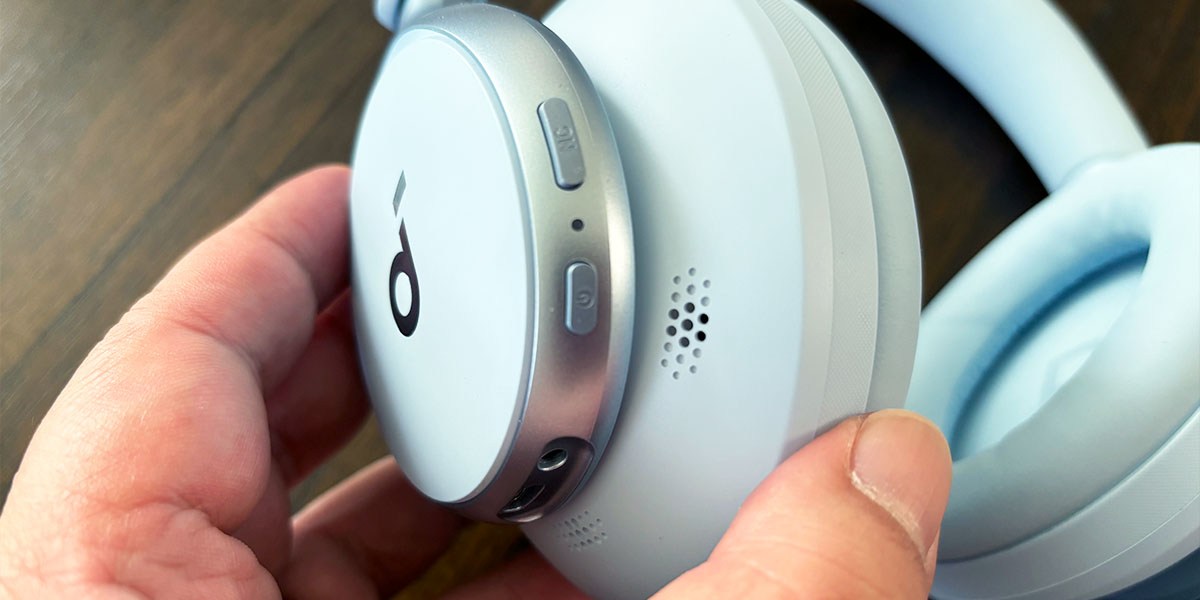 Fingers holding light blue Soundcore Space Ones earpiece Fingers holding light blue Soundcore Space Ones earpiece