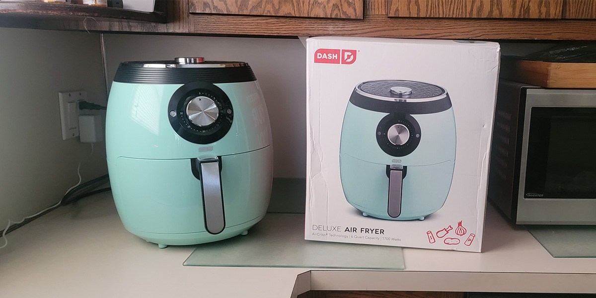 Aqua Dash Deluxe Air Fryer on counter next to brand packaging Aqua Dash Deluxe Air Fryer on counter next to brand packaging